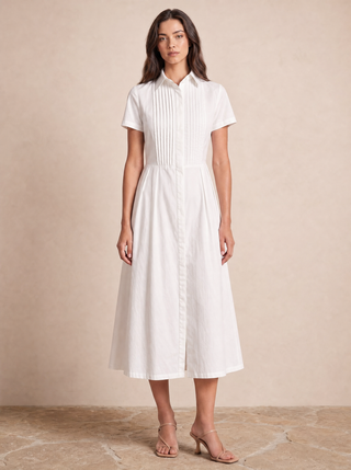 Delphine white cotton shirt-dress, styled campaign image with hand-pressed pintuck bib
