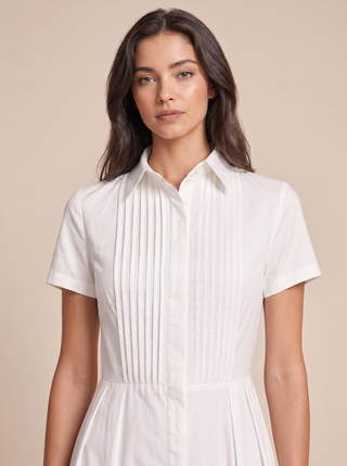 Close-up of the hand-pressed pintuck bib and concealed button placket on the Delphine cotton poplin shirt-dress