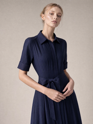 Simone pleated shirt-dress, seated pose showing pleat fall and pointed collar